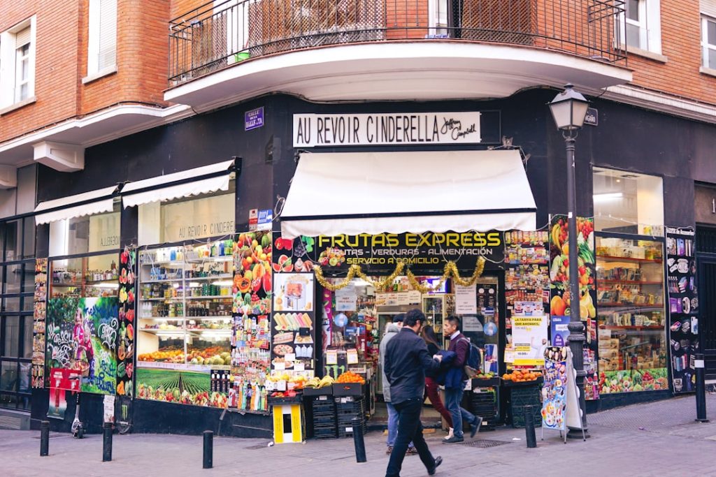 a-man-walking-past-a-fruit-and-vegetable-stand-2melpce5wd4